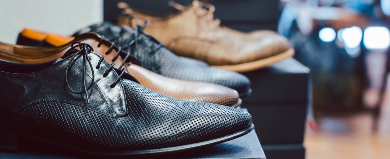 collection de chaussures habillées pour homme exposées en vitrine de magasin