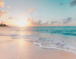 coucher de soleil sur plage tropicale avec vagues et sable blanc doré