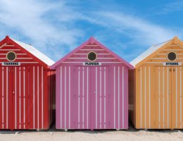 Vibrant beach huts on a sunny day in Cucq, France.