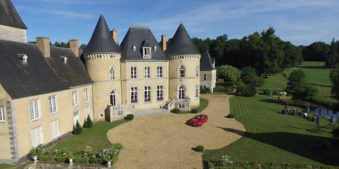 aerial view photography of red vehicle park in front of building