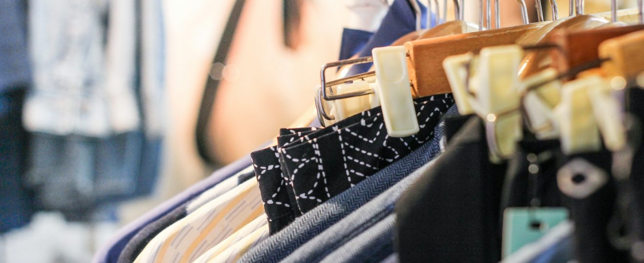 vêtements d'occasion sur cintres dans une boutique de seconde main