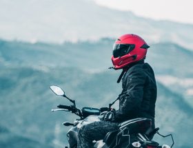 a man riding a motorcycle with a mountain in the background