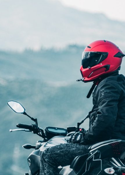 a man riding a motorcycle with a mountain in the background