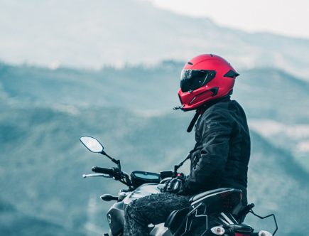 a man riding a motorcycle with a mountain in the background