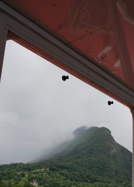 Misty mountain view from a window with a red ceiling.