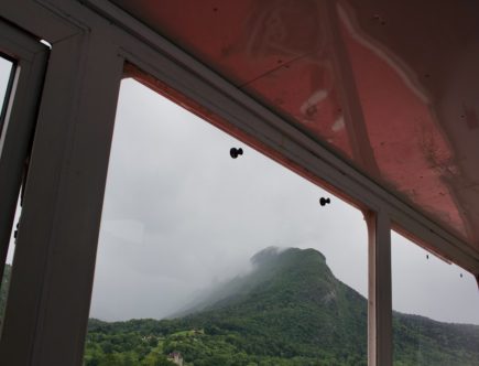 Misty mountain view from a window with a red ceiling.