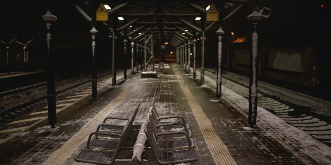 a train station with benches covered in snow