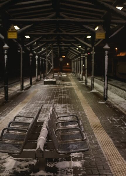 a train station with benches covered in snow