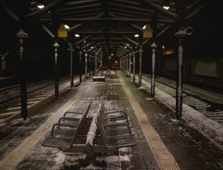 a train station with benches covered in snow