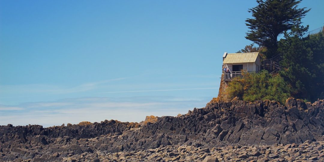 brown and white house on rocky hill under blue sky during daytime