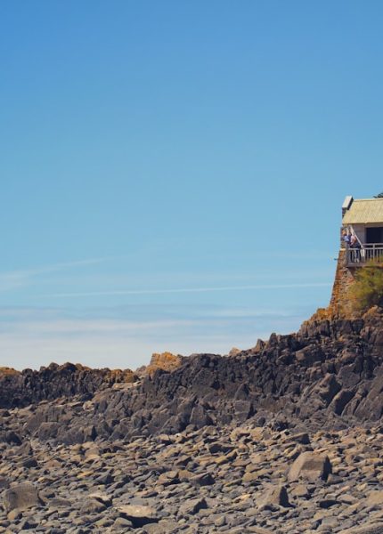 brown and white house on rocky hill under blue sky during daytime