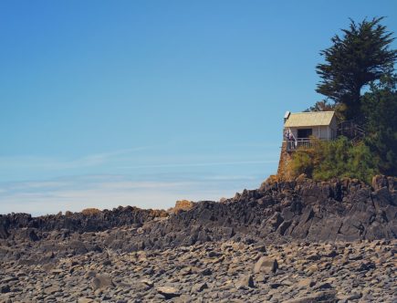 brown and white house on rocky hill under blue sky during daytime