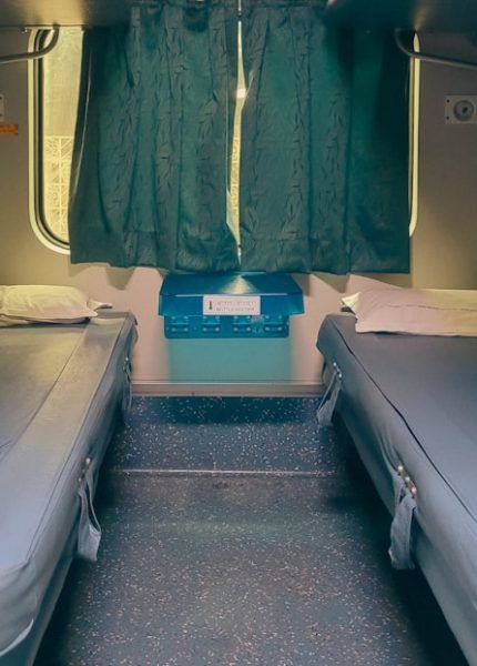 Two beds inside a train cabin.